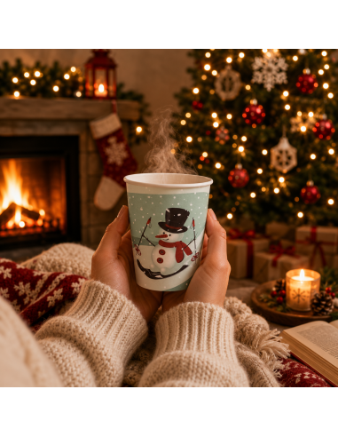 Gobelet de Noël tenu en main devant une cheminée allumée - Packadi