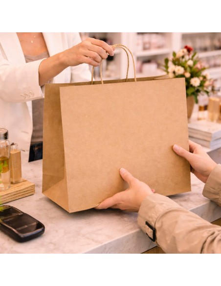 Sac en papier kraft brun remis à un client au-dessus du comptoir d'un magasin